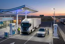 Launch of World-First Hydrogen Intelligence System in U.S. Hydrogen fueling station at dusk with a large truck and a car refueling under a lit canopy.