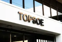 Topsoe Alters Development and Commercialization of SOEC Modern office building facade with a large TOPSOE sign on a white wall and glass windows above
