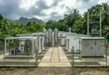 Hydrogen Power Plants in Philippines by French Company Outdoor industrial facility with silver tanks and machinery inside a chain-link fence, set in a tropical, tree-filled area.