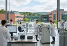 First g-HIB battery in World for Efficient Hydrogen Storage Scientists in white lab coats work at benches in a bright, modern lab with various instruments and monitors; hydrogen tanks are visible on the right.
